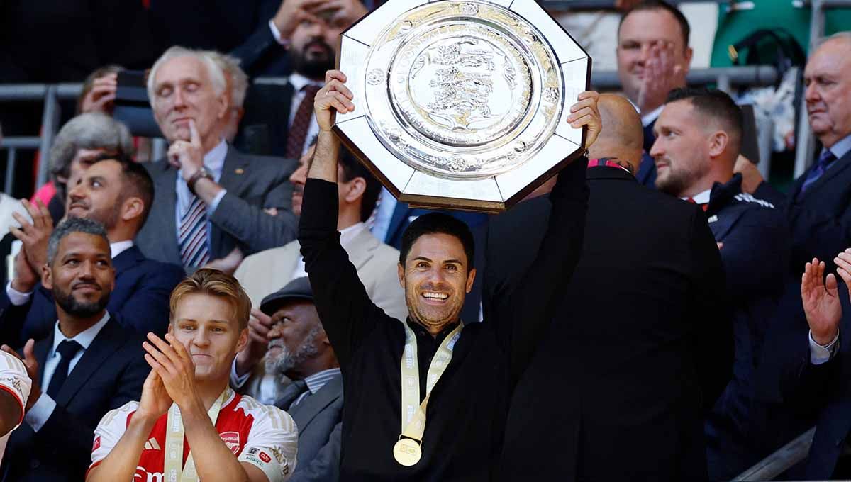 Pelatih Arsenal Mikel Arteta merayakan dengan trofidi di laga Community Shield Manchester City vs Arsenal (06/08/23). (Foto: REUTERS/Peter Cziborra) Copyright: © REUTERS/Peter Cziborra