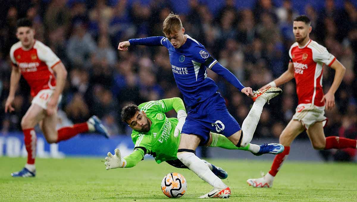 Pemain Chelsea, Cole Palmer, coba melewati kiper Arsenal, David Raya di Liga Inggris. Copyright: © Reuters/Peter Cziborra