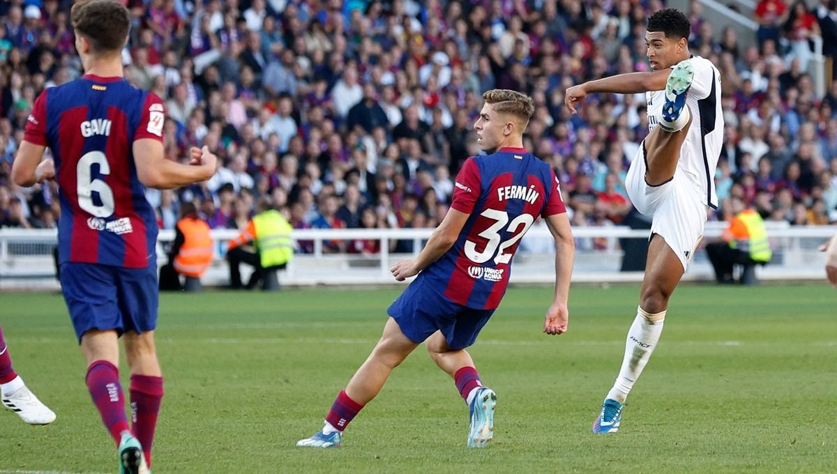 Jude Bellingham melepaskan tembakan berbuah gol di laga Barcelona vs Real Madrid. (Foto: REUTERS/Albert Gea) Copyright: © REUTERS/Albert Gea