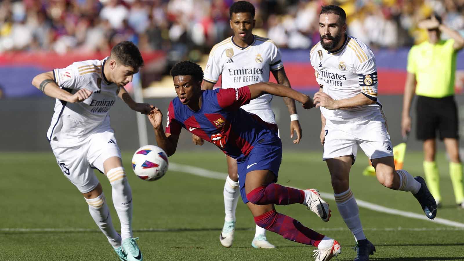 Pemain Barcelona Alejandro Balde dihadang pergerakannya oleh pemain Real Madrid  Federico Valverde pada laga LaLiga Spanyol di Stadion Olímpic Lluís Companys (Barcelona), Sabtu (28/10/23). (Foto: REUTERS/Albert Gea) Copyright: © REUTERS/Albert Gea