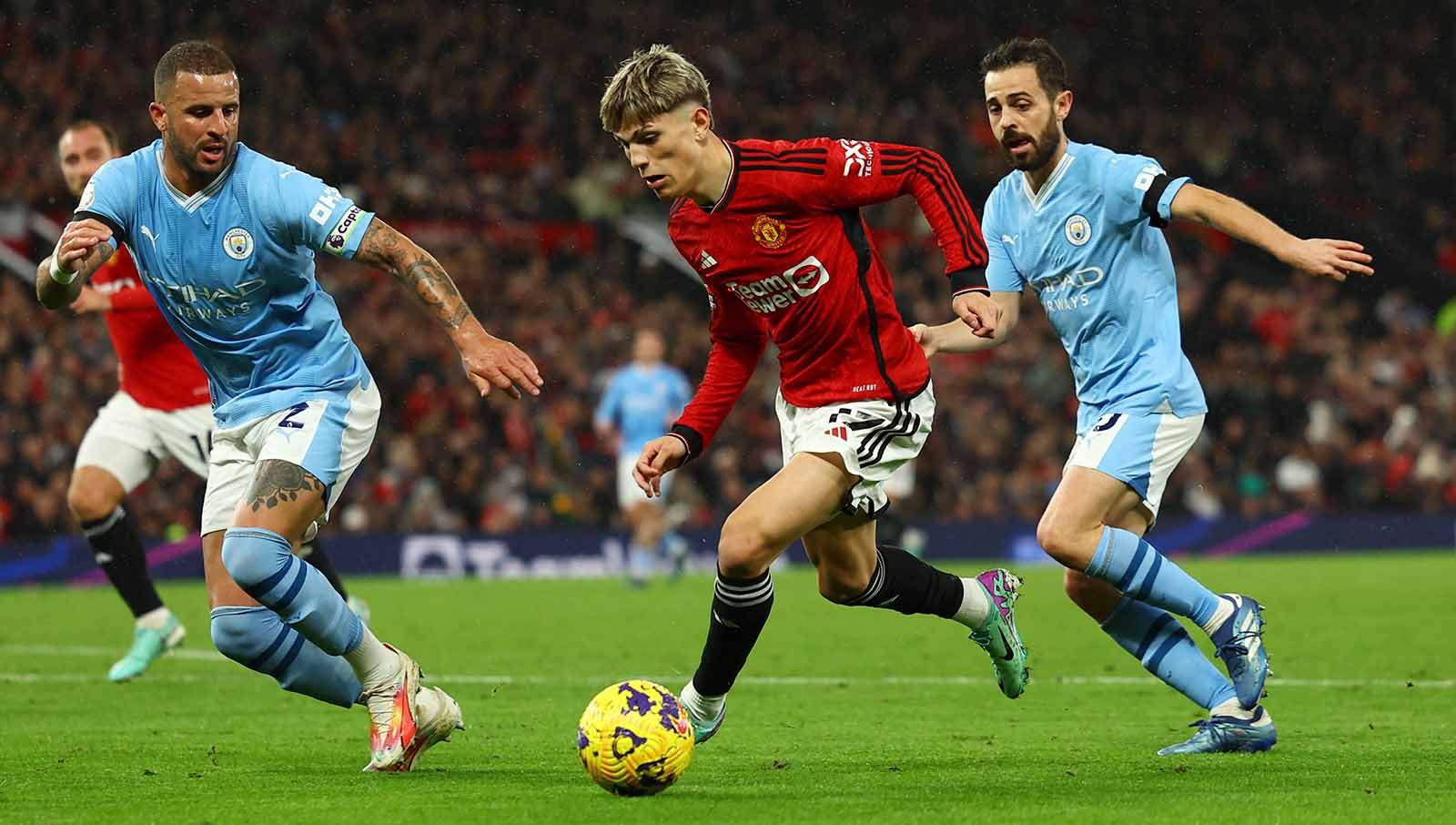 Alejandro Garnacho mendapat pengawalan ketat dari pemain Manchester City Kyle Walker dan Bernardo Silva pada laga Liga Inggris di Stadion Old Trafford, Manchester, Inggris. (Foto: REUTERS/Molly Darlington) Copyright: © REUTERS/Molly Darlington