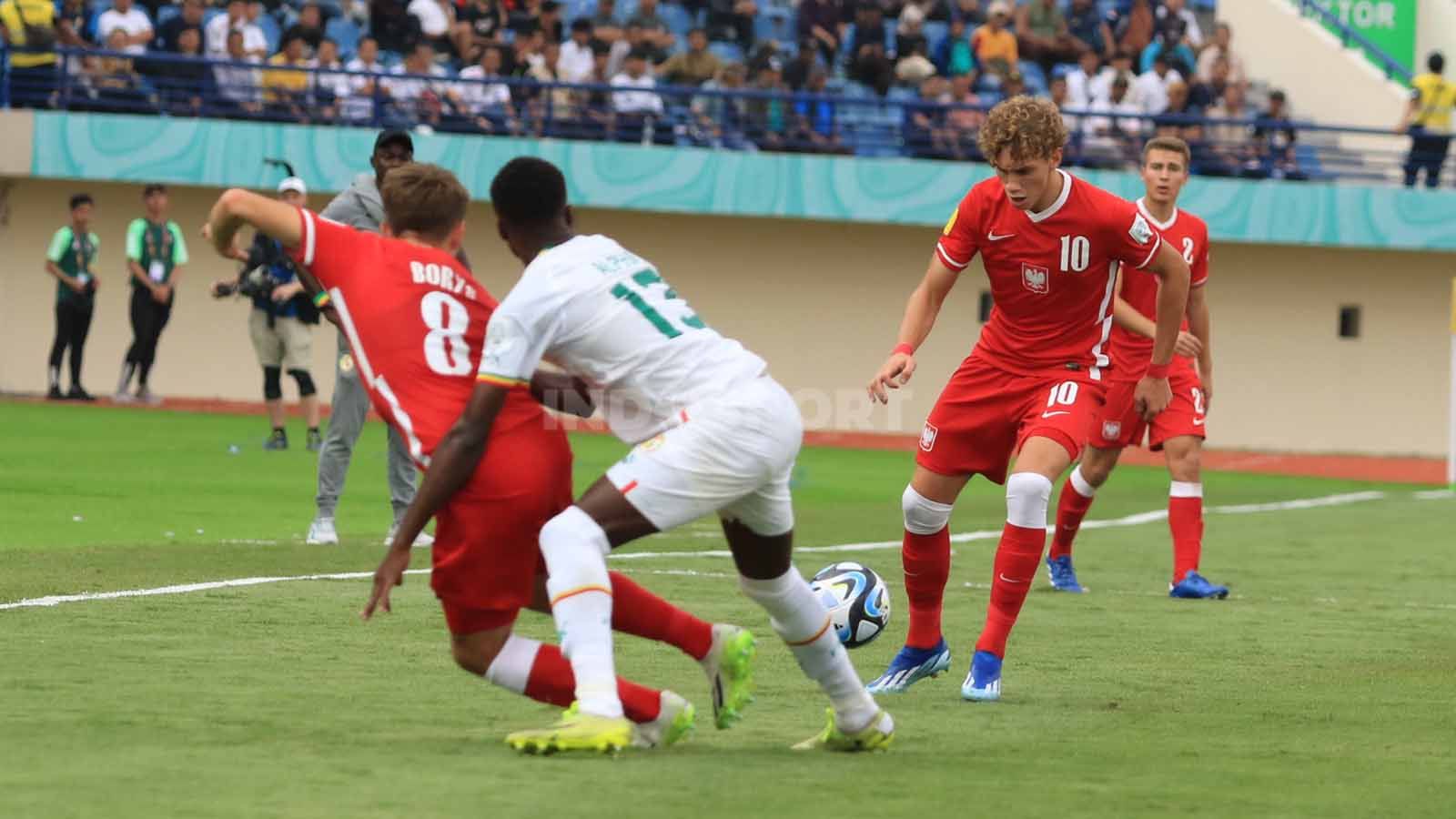 Striker Timnas Polandia U-17, Mikolajewski Daniel mendapatkan pengawalan ketat dari pemain Timnas Senegal U-17, pada pertandingan Grup D Piala Dunia U-17 2023 di Stadion Si Jalak Harupat, Kabupaten Bandung, Selasa (14/11/23). Copyright: © Arif Rahman/INDOSPORT