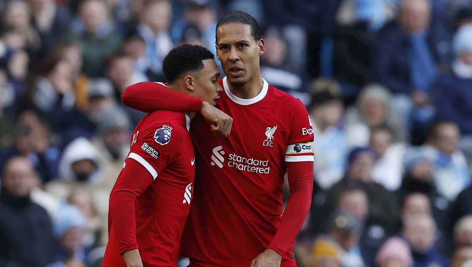 Trent Alexander-Arnold merayakan gol bersama Virgil van Dijk di laga kontra Manchester City, Sabtu (25/11/23). Foto: Reuters/Jason Cairnduff. Copyright: © Reuters/Jason Cairnduff