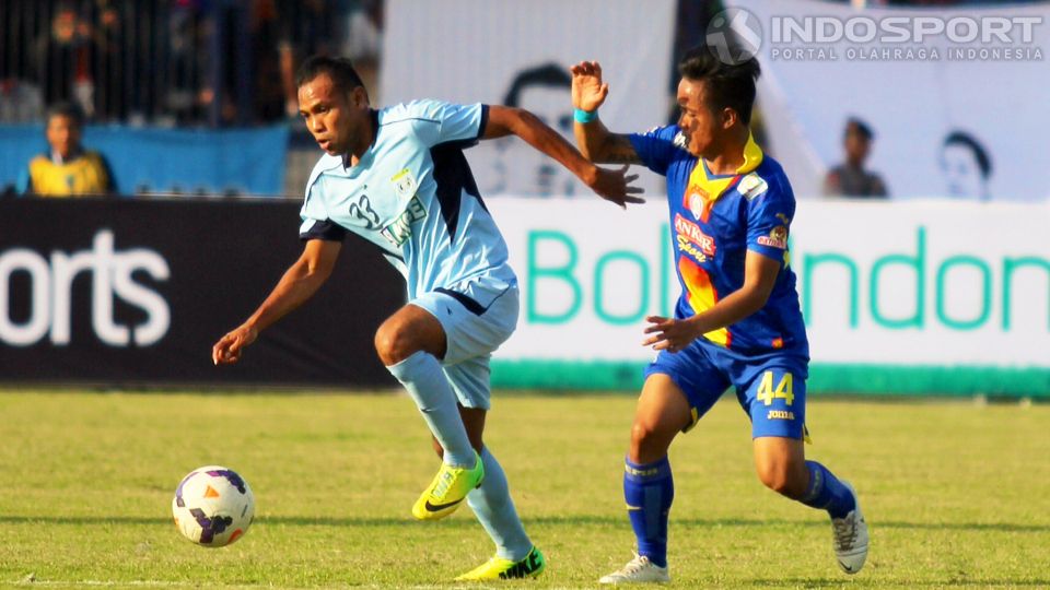 Pemain Persela Lamongan, Burhanudin Nihe, saat berhadapan dengan gelandang Arema Cronus, I Gede Sukadana, dalam laga 8 besar ISL 2014 di Stadion Surajaya, Lamongan, Rabu (08/10/14). Laga itu berakhir 2-2. Copyright: &copy; Ardiyansyah/INDOSPORT