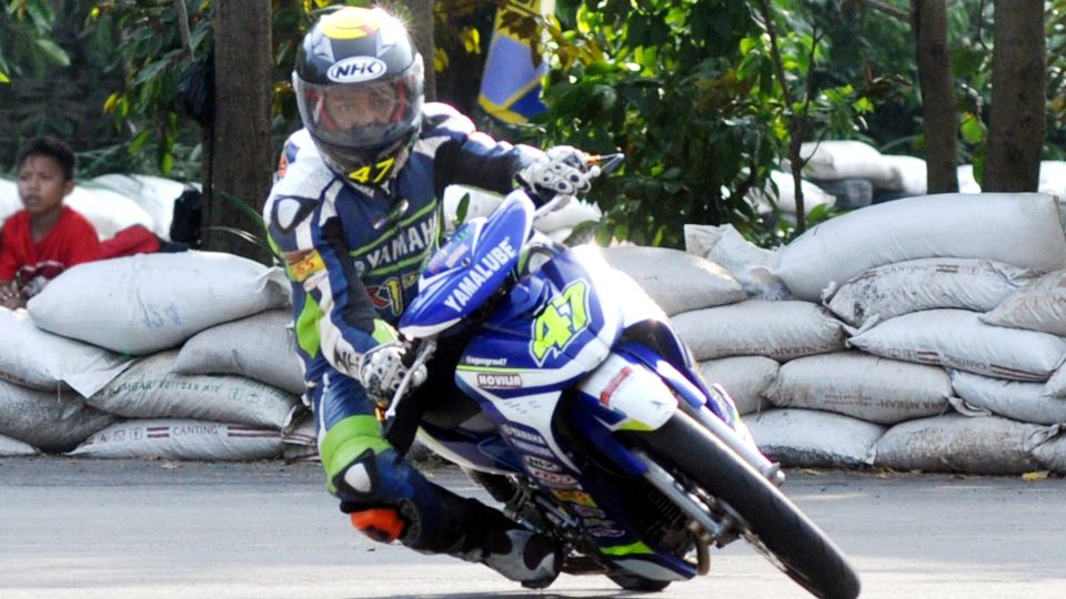 Pebalap muda Solo, Agus Setiawan alias Iwan, rebut trofi Juara Nasional Motoprix kelas MP 1 125 cc Tune-up Seeded 2014, setelah menjadi runner-up di seri terakhir di Purwokerto, Minggu (19/10/14). Copyright: © Raditya Erwiyanto/INDOSPORT